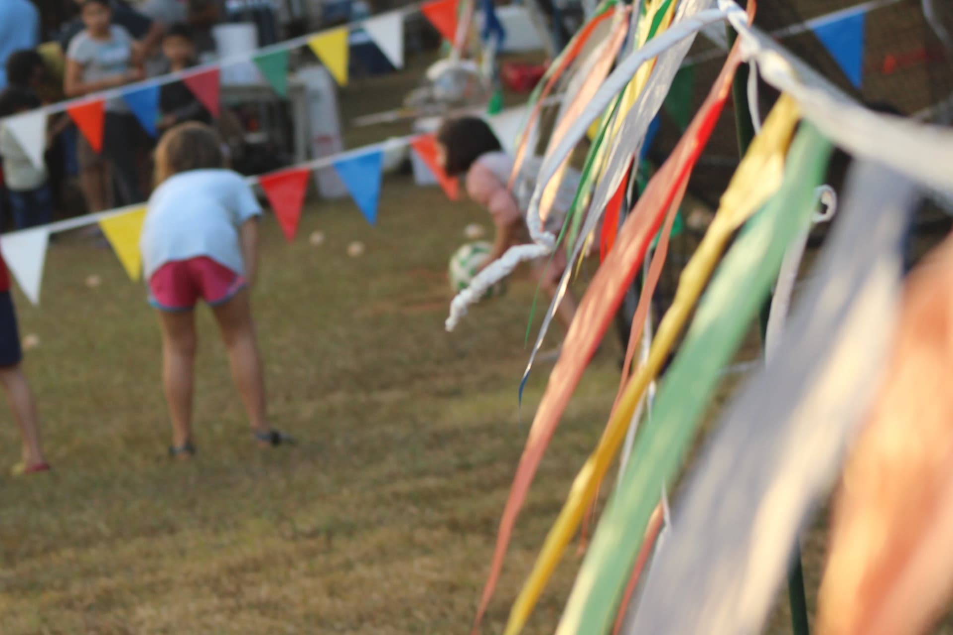 Families at a community fete with gazebos and bunting